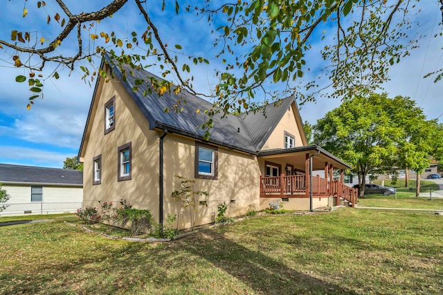 view of side of property featuring a yard and covered porch