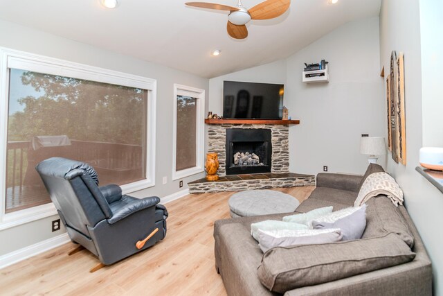 dining area featuring light hardwood / wood-style floors, ceiling fan with notable chandelier, a fireplace, and vaulted ceiling