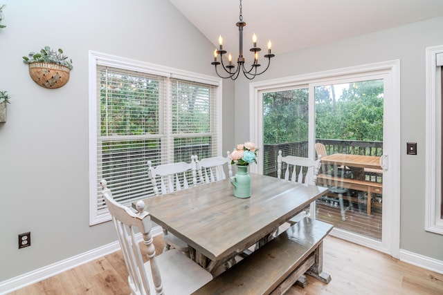 dining room with light hardwood / wood-style flooring, a notable chandelier, plenty of natural light, and lofted ceiling