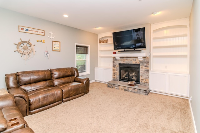 living room with a stone fireplace, carpet floors, and built in features