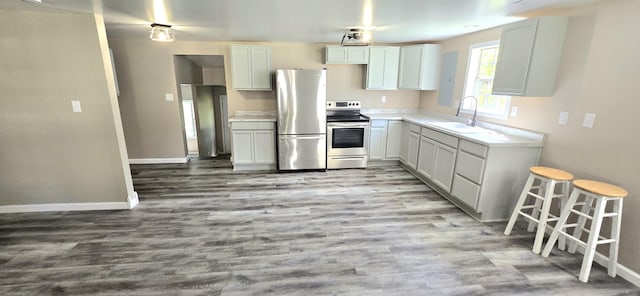 1835 Echo Point Rd, Bronston, KY 42518 - kitchen with appliances with stainless steel finishes, a sink, baseboards, wood finished floors, and light countertops