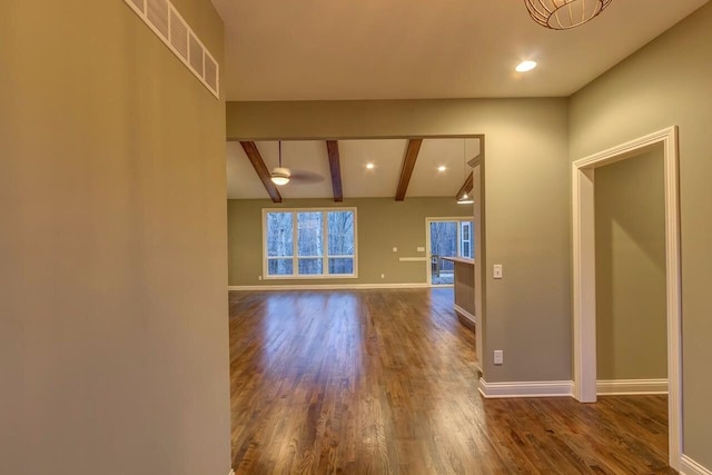 spare room featuring vaulted ceiling with beams and dark wood-type flooring