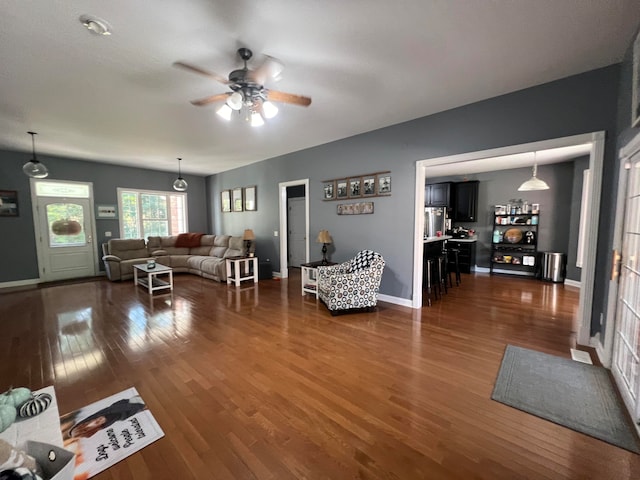 living room featuring ceiling fan and dark hardwood / wood-style floors