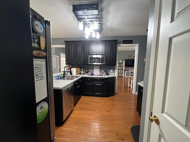 kitchen featuring stainless steel appliances, light wood-type flooring, and sink