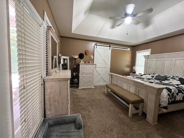 bedroom featuring carpet floors, a barn door, multiple windows, and ceiling fan