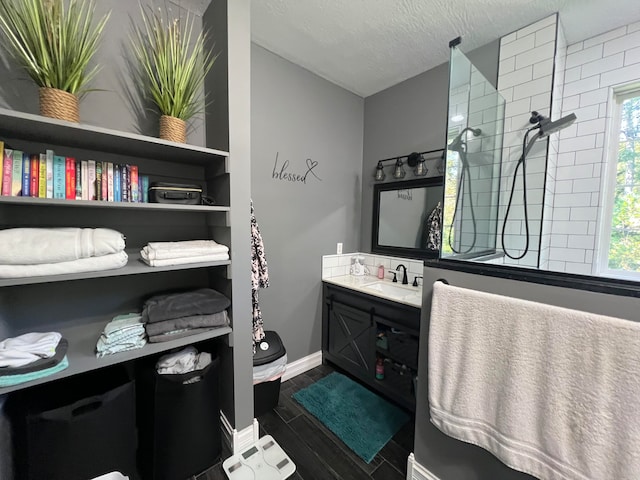 bathroom featuring a textured ceiling, hardwood / wood-style flooring, vanity, and a wealth of natural light