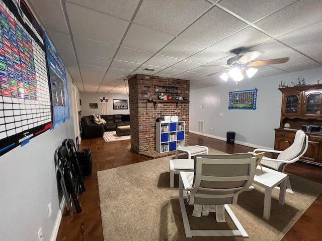 living room with ceiling fan and a drop ceiling