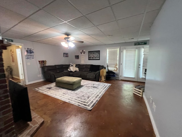 living room with a paneled ceiling and ceiling fan