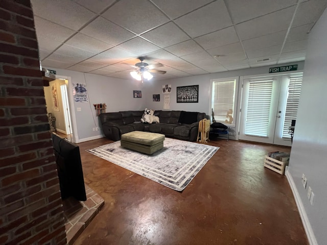 living room with ceiling fan and a drop ceiling