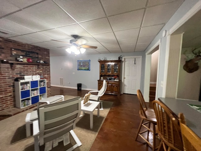 dining area with a drop ceiling and ceiling fan