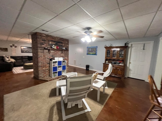 living room with ceiling fan and a paneled ceiling