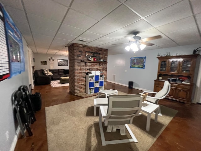 living room with a drop ceiling and ceiling fan