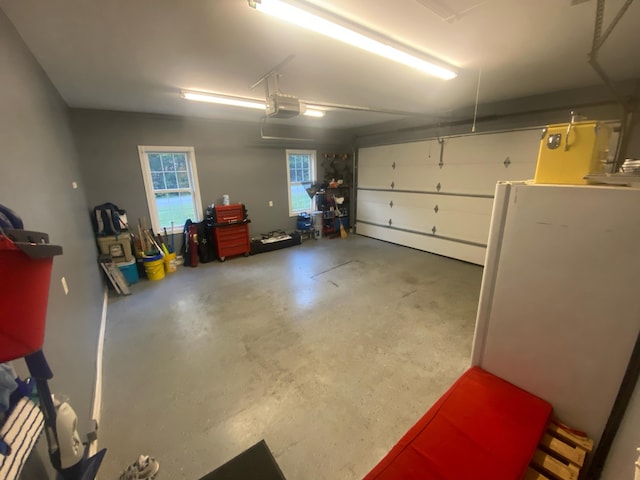 garage featuring a garage door opener and white refrigerator