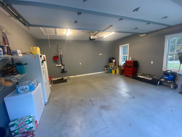 garage with a garage door opener and white fridge