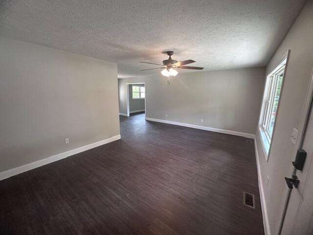 unfurnished room featuring a textured ceiling, dark hardwood / wood-style floors, and ceiling fan