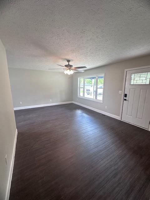 interior space with ceiling fan, dark wood-type flooring, and a textured ceiling