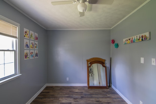 unfurnished room with ceiling fan, plenty of natural light, dark wood-type flooring, and crown molding