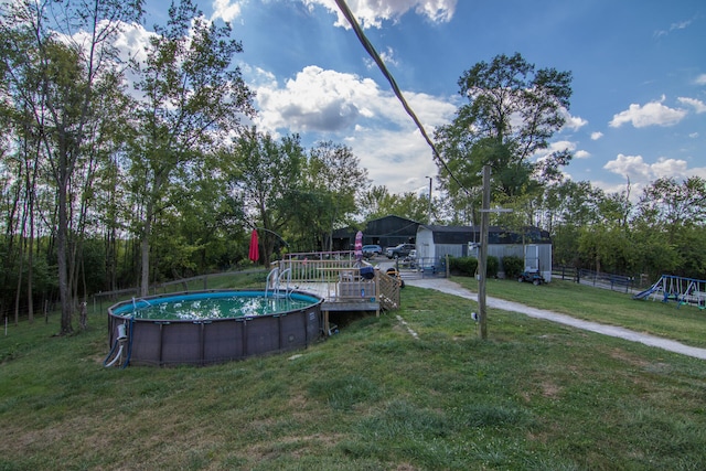 view of swimming pool featuring a shed, a yard, and a playground