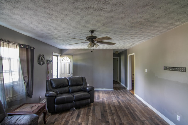 unfurnished living room featuring a textured ceiling, dark hardwood / wood-style floors, and ceiling fan