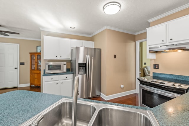 kitchen featuring ceiling fan, stainless steel appliances, white cabinets, dark hardwood / wood-style flooring, and ornamental molding