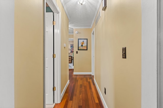 hall with wood-type flooring, a textured ceiling, and ornamental molding