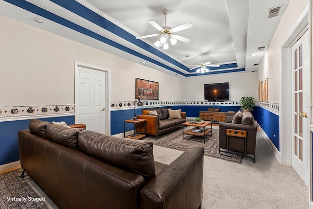 living room with carpet flooring, ceiling fan, and a raised ceiling