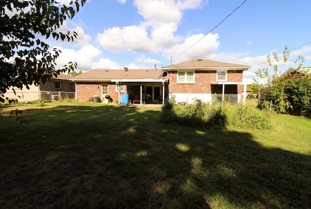 rear view of property with a lawn