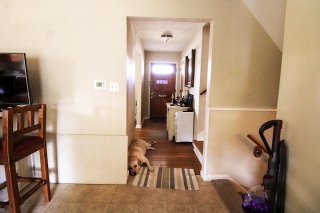 corridor featuring a textured ceiling and dark wood-type flooring