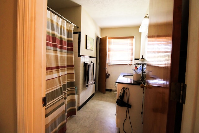 bathroom with vanity, tile walls, toilet, and a shower with shower curtain