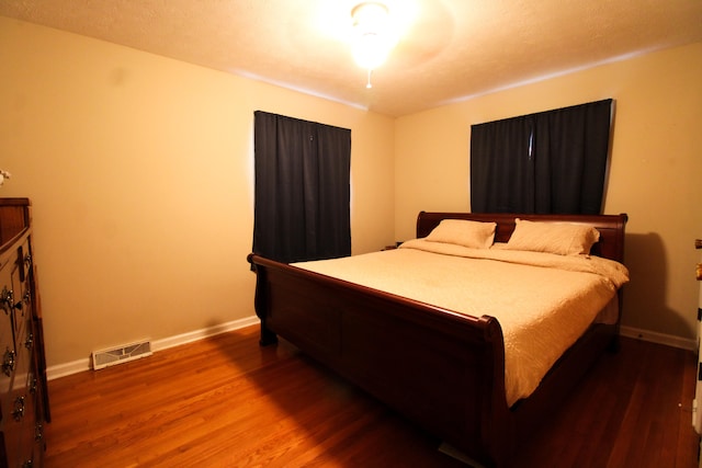 bedroom with dark hardwood / wood-style flooring