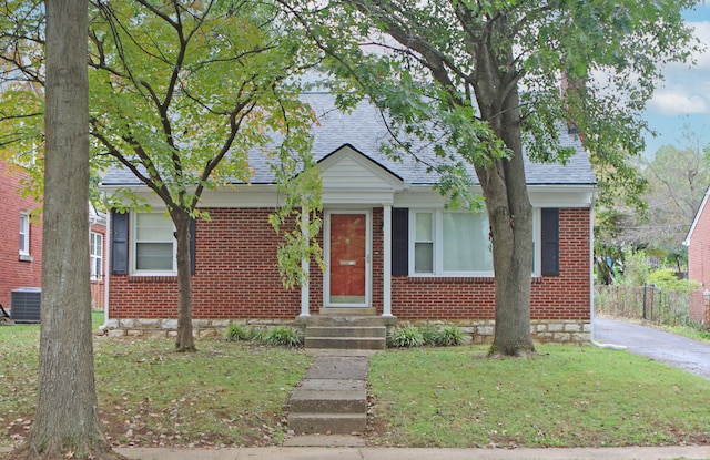 view of front of property with a front lawn and central air condition unit