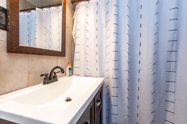 bathroom with decorative backsplash, vanity, and curtained shower