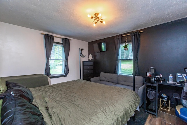 bedroom featuring a textured ceiling and dark hardwood / wood-style floors