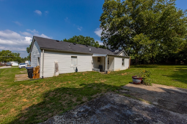 rear view of house featuring a yard