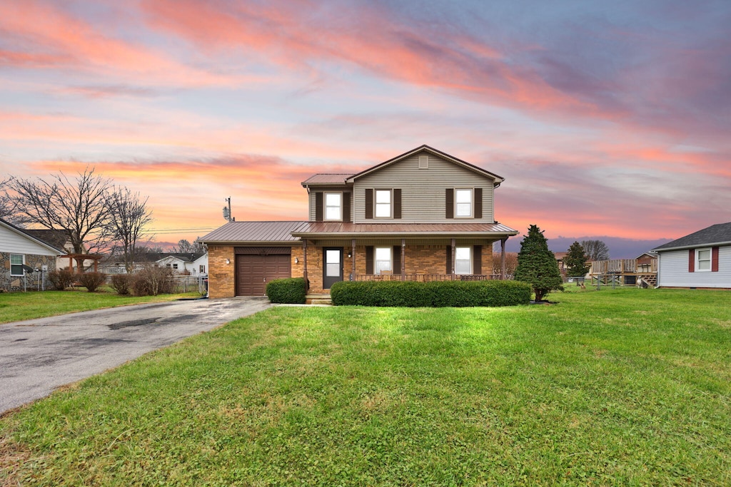 view of front of home featuring a lawn and a garage