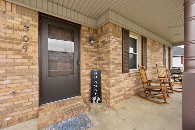 view of exterior entry featuring covered porch