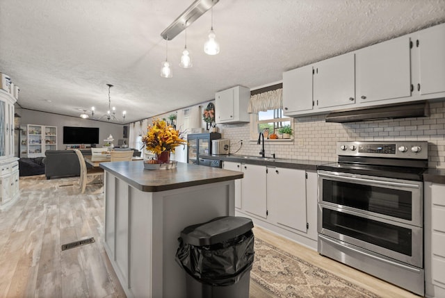 kitchen with an inviting chandelier, decorative light fixtures, white cabinetry, and double oven range