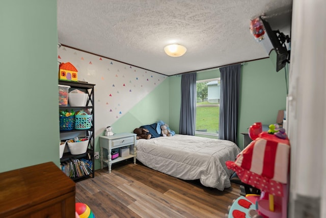 bedroom with vaulted ceiling, a textured ceiling, and dark wood-type flooring