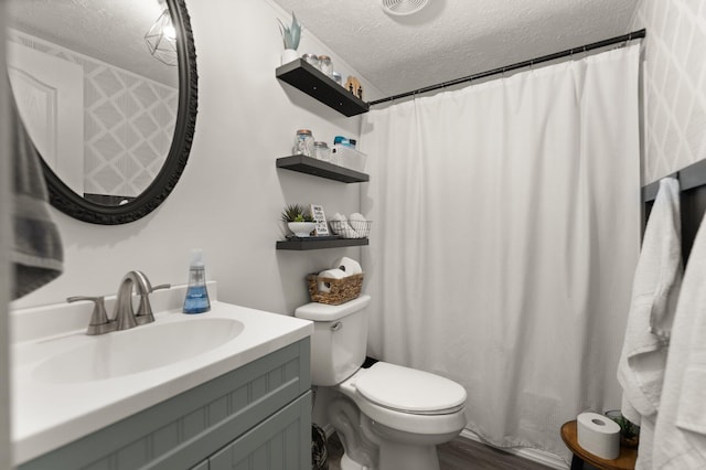 bathroom featuring a textured ceiling, hardwood / wood-style flooring, a shower with curtain, vanity, and toilet