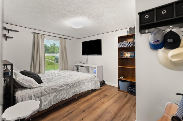 bedroom featuring a textured ceiling and wood-type flooring