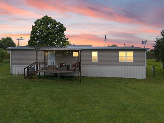 back house at dusk featuring a yard