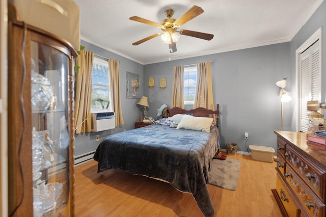 bedroom featuring ceiling fan, ornamental molding, light hardwood / wood-style flooring, baseboard heating, and a closet