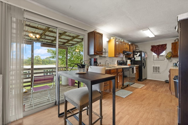 kitchen with light hardwood / wood-style floors, a textured ceiling, black appliances, crown molding, and sink