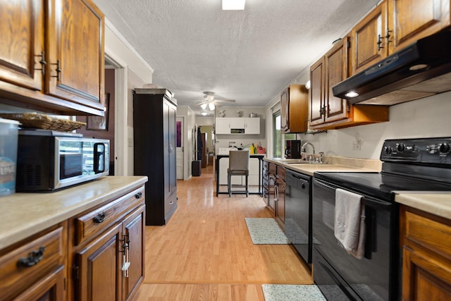 kitchen with a textured ceiling, black appliances, ceiling fan, light hardwood / wood-style flooring, and sink