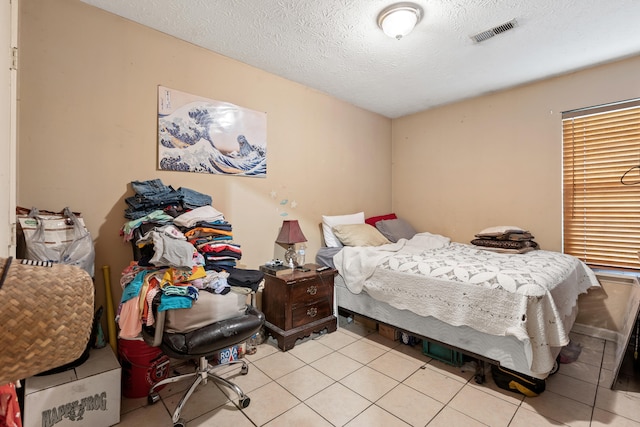 bedroom with a textured ceiling and light tile patterned floors