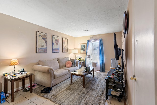 tiled living room featuring a textured ceiling