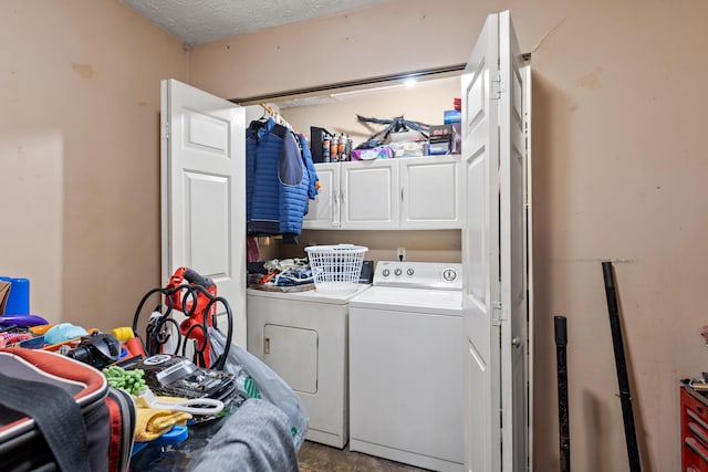 clothes washing area featuring cabinets, washer and dryer, and a textured ceiling