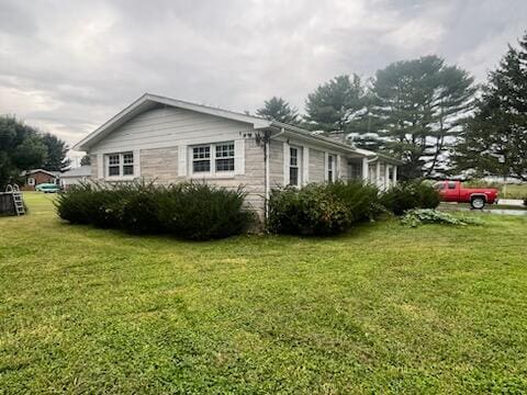 view of side of home with a yard