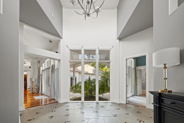 foyer featuring an inviting chandelier, a high ceiling, and light hardwood / wood-style floors