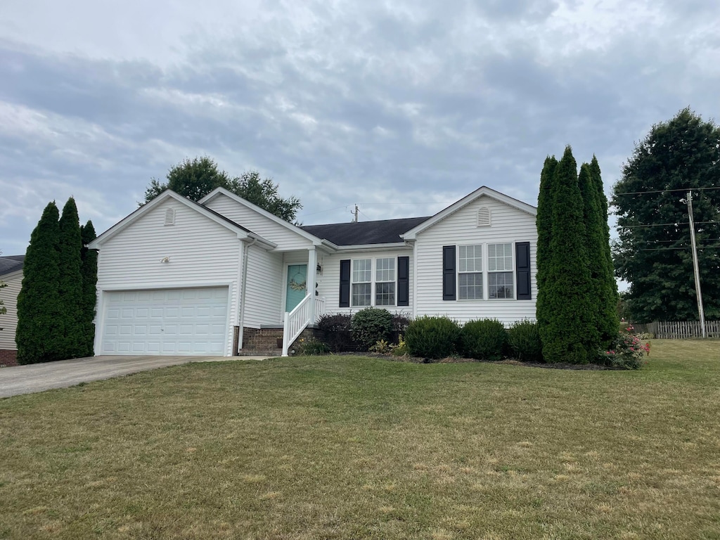 ranch-style home with a garage and a front lawn